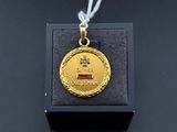 l'image d'une médaille d'or posée sur une boîte noire