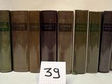 Plusieurs vieux livres sont alignés sur une table, accompagnés d'une étiquette de prix
