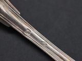 two silver spoons and a fork on a black surface