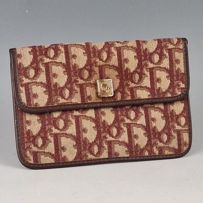 sac à main marron et beige, orné d'un monogramme sur fond gris