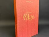 a red book with gold lettering on it sitting on a table