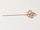 une broche en forme de fleur dorée sur un fond blanc