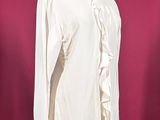 a white shirt with ruffles on a mannequin stand
