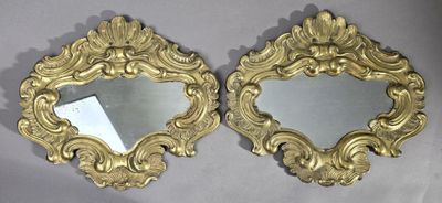 une paire de miroirs en or richement décorés sur fond blanc
