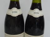 two bottles of wine sitting on top of a table next to each other