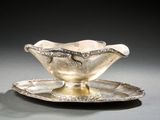 a silver plate with a bowl on it on a table