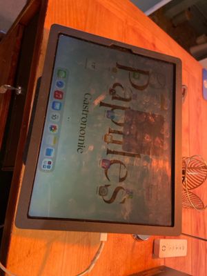 a tablet computer sitting on top of a wooden desk