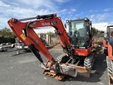 a red excavator that is sitting in the parking lot
