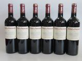 six bottles of red wine lined up in a row on a table