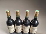 four bottles of wine are lined up on a table