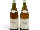 deux bouteilles de vin posées l'une à côté de l'autre sur une surface blanche