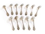six silver spoons are arranged in a row on a white surface