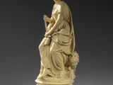 a statue of a woman reading a book on a pedestal