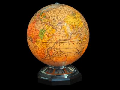 un grand globe terrestre posé sur un socle, sur fond noir