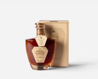 a bottle of brandy sitting next to a box on a white surface