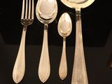 five silver spoons and two silver spoons on a black table