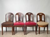four wooden chairs are lined up against a wall in a row