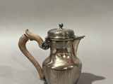 an antique silver plated coffee pot with a wooden handle