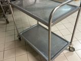 a metal cart that is on the floor in a kitchen