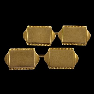 a set of four gold plated cufflinks on a black background