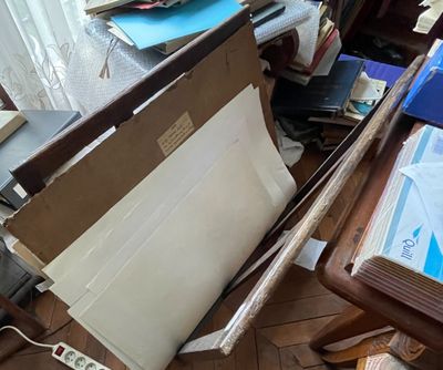 une pile de papiers posée par terre à côté d'un bureau
