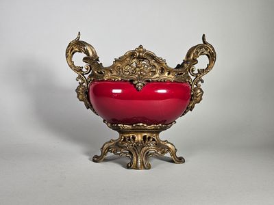 un vase rouge orné d'un motif doré sur le dessus