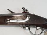an old gun that is on display on a white surface