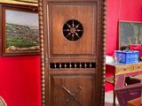 a tall wooden cabinet in a room with a painting on the wall