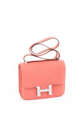 a small pink bag with a metal handle on a white background