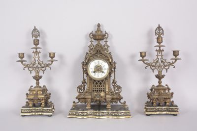 three antique clocks are sitting next to each other on a white surface