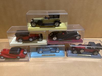 five different models of cars in a display case