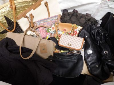 many purses and handbags on the bed together