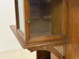 a wooden cabinet with a glass door on top of it