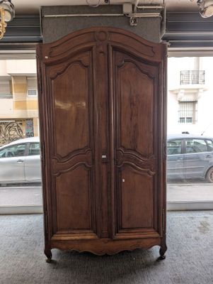 a large wooden armoire in a room with a car in the background