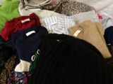 un tas de vêtements sur un lit recouvert d'une couverture à imprimé léopard