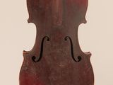 un vieux violon suspendu à une ficelle sur un mur blanc