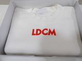 white t - shirt with red dgm logo in a white box