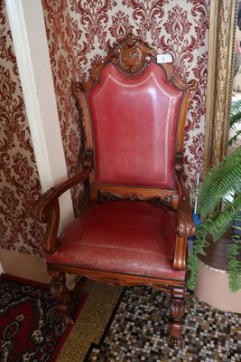 un fauteuil en cuir rouge dans une pièce au papier peint rouge