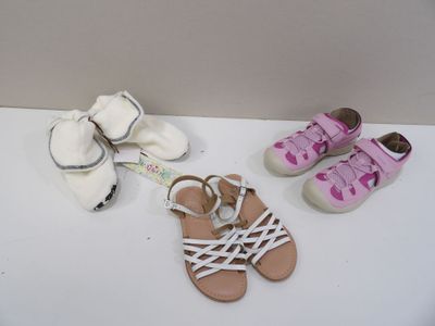 trois paires de sandales et une paire de chaussures posées sur une table