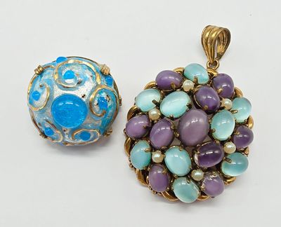 two pendants of blue and purple stones on a white surface