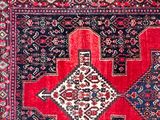 an oriental rug with a diamond design on a red ground