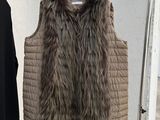 two coats hanging on a clothes rack in a room
