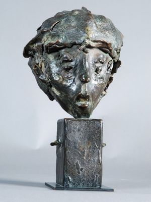 sculpture of a woman ' s head on a metal stand on a white background