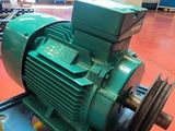 a green electric motor on a blue stand in a room