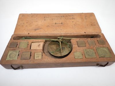 an old wooden box with a clock on top of it on a white surface