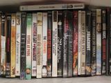 many dvds stacked on a shelf in a white box