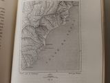 someone is holding a book open to a map of the country