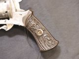 a silver revolver with a wooden handle on a table