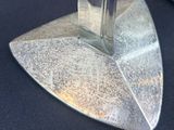 a glass of water sitting on top of a metal stand