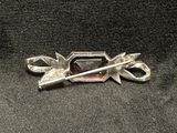 a silver brooch that has scissors on it